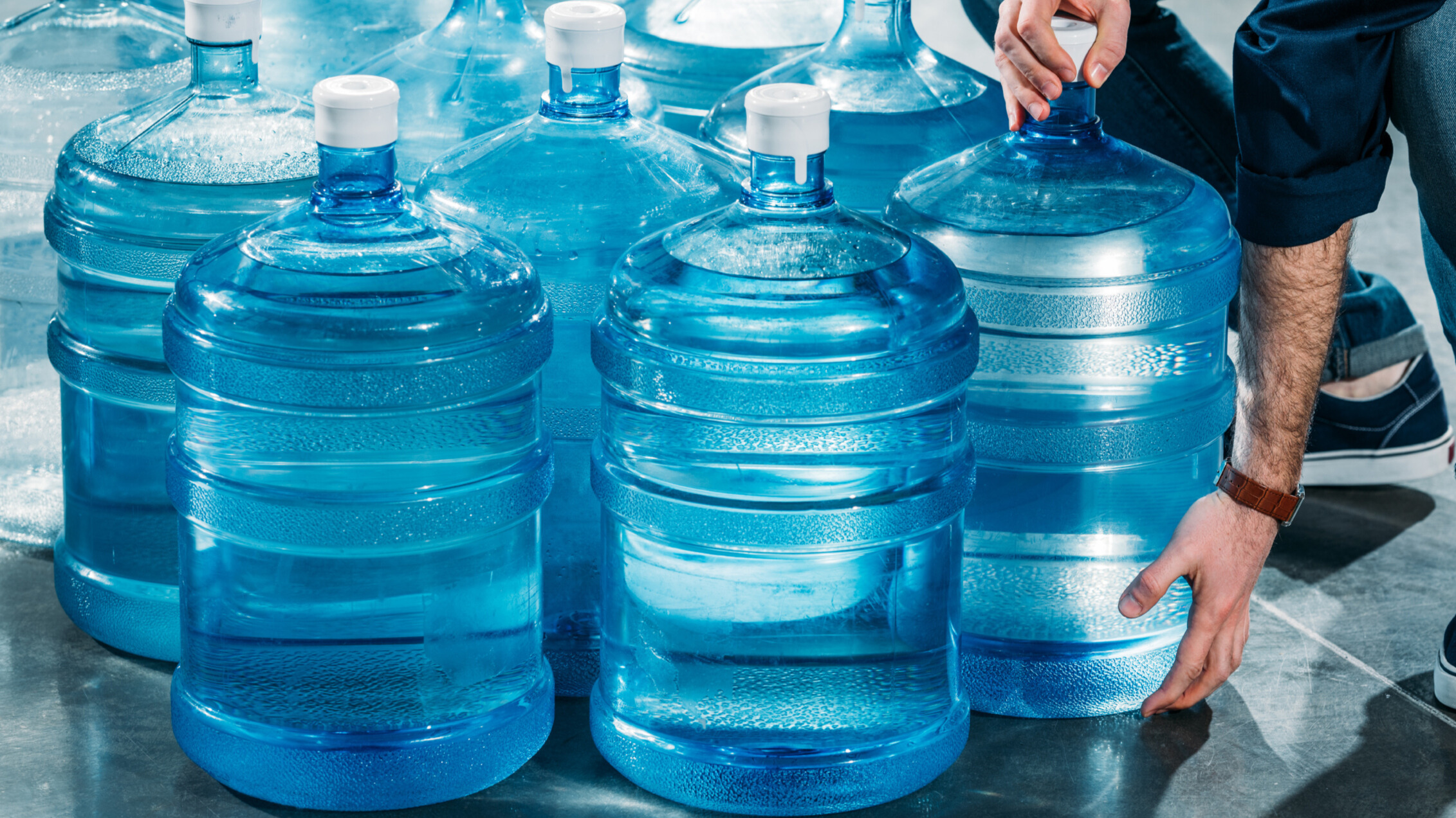 Person filling clean water jugs for emergency storage